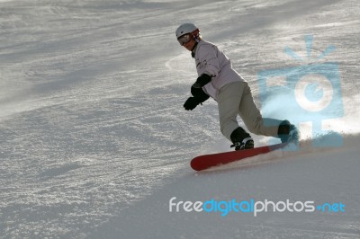 Female Snowboarder In Powder Snow Stock Photo