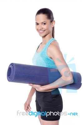 Female Trainer Holding Exercise Mat Stock Photo