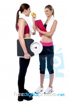 Female Trainer Writing Diet Chart For Gym Member Stock Photo