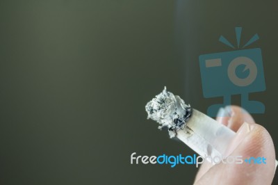 Finger And Tobacco Cigarette With Copy Space, Blank Pastel Grey Stock Photo