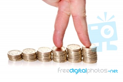 Fingers Walking Up On Stacks Of One Pound Coins Stock Photo