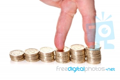 Fingers Walking Up On Stacks Of One Pound Coins Stock Photo