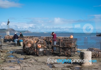 Fishermen Repairing Their Lobster Pots On The Harbour Wall At Ly… Stock Photo