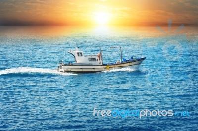Fishing Boat In Sea At Sunset Stock Photo