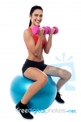 Fit Woman In Gym Working Out With Dumbbells Stock Photo