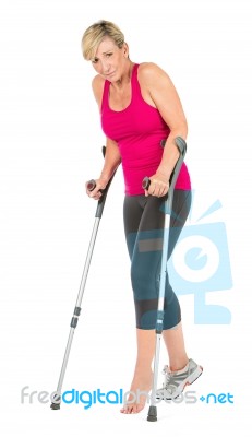 Fitness Woman Walking With Crutches Stock Photo