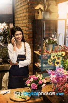 Florist Standing At Her Flower Shop And Using Her Telephone To T… Stock Photo