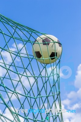 Football Caught In Goal Net With Blue Sky Stock Photo