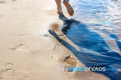 Footprints In The Wet Sand Of The Beach Stock Photo