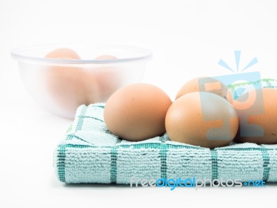 Four Egg On Fabric And Egg In Clear Cup Isolated On White Background Stock Photo