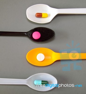 Four Spoons With Different Pills  Stock Photo