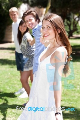 Four Teens Hang Out In A Park Stock Photo
