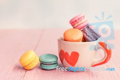 French Macarons In Cup On Pink Wooden Background.toned Image Stock Photo
