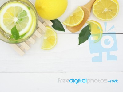 Fresh Lemon In Water And Lemon Slice On White Wood Background Stock Photo