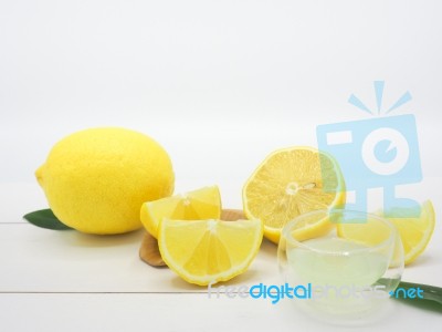 Fresh Lemon Juice In A Small Bowl And Lemon Slice On White Wood Stock Photo