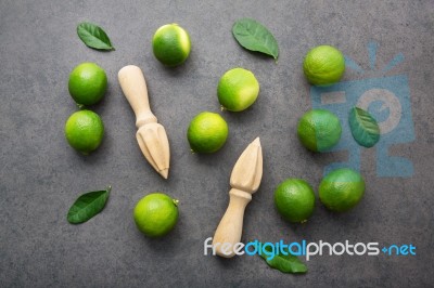 Fresh Limes And Wooden Juicer On White Background. Top View Stock Photo