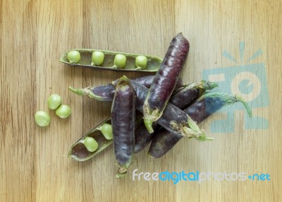 Fresh Violet Peas Isolated On A Wooden Background Stock Photo