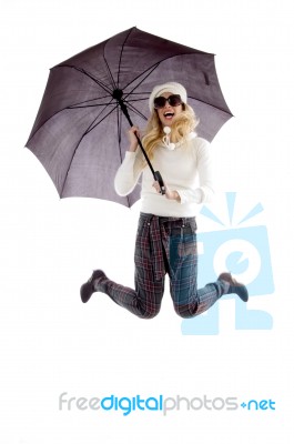 Front View Of Jumping Woman Holding An Umbrella Stock Photo