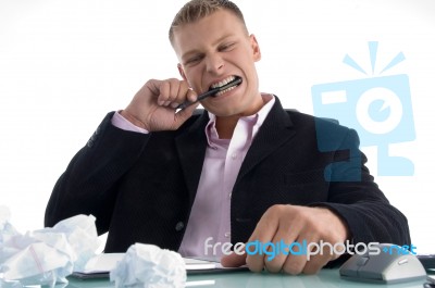 Frustrated Businessman Biting Pen Stock Photo
