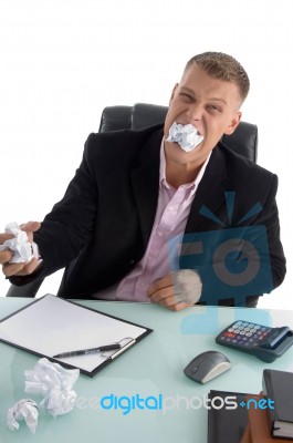 Frustrated Businessman eating Paper Stock Photo