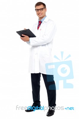 Full Length Shot Of Physician Posing With Clipboard Stock Photo