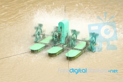 General Small Green Water Turbine Spin In Public Pond Stock Photo