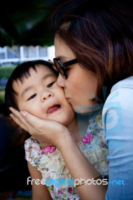 Girl Children And Mom Kissing On Cheek With Lovely Face Stock Photo