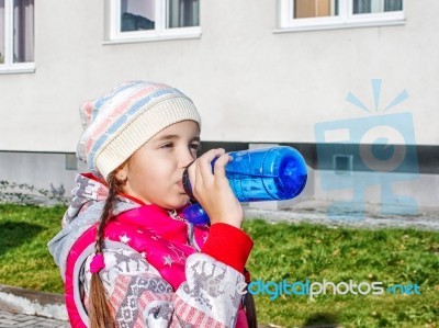 Girl Drinking Water From A Bottle On The Street In Autumn Stock Photo