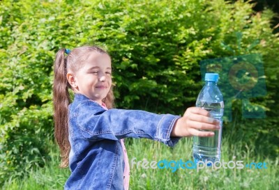 Girl Giving A Plastic Bottle With Water Stock Photo