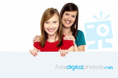 Girl Holding Ad Board With Her Mother Behind Her Stock Photo