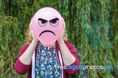 Girl Holding Balloon With Angry Face Stock Photo