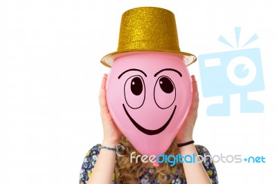 Girl Holding Balloon With Smiling Face And Hat Stock Photo