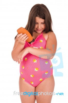 Girl In Swimsuit Applying Sun Lotion Stock Photo