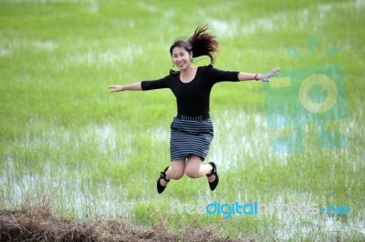 Girl Jumping In Paddy Field Stock Photo