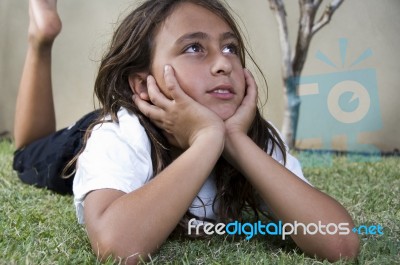 Girl Lying On Grass And Daydreaming Stock Photo