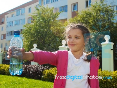 Girl Offering A Plastic Bottle With Water Stock Photo