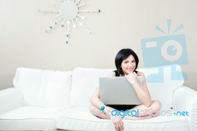 Girl On White Sofa With Laptop Stock Photo