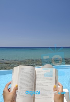 Girl Reading A Book On A Beach Stock Photo