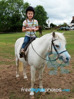 Girl Riding A Grey Pony Stock Photo
