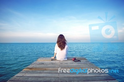Girl Sitting Alone On A The Wooden Bridge On The Sea. Vintage Tone Style. (frustrated Depression) Stock Photo Girl Sitting Alone On A The Wooden Bridge On The Sea. Vintage Tone Style. (frustrated Depression) Stock Photo