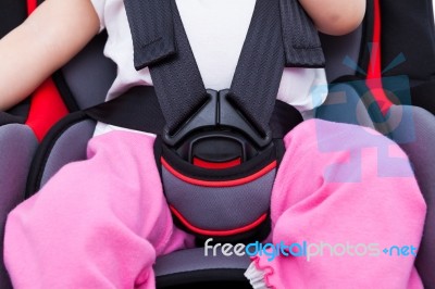 Girl Sitting At Carseat And Fasten Seat Belt. Concept About The Safety Of Traveling By Car Stock Photo