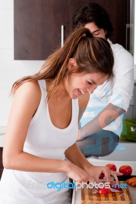 Girl Slicing Tomato In Kitchen Stock Photo