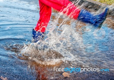 Girl Standing In A Puddle Of Water Splashes Stock Photo