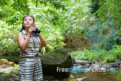 Girl Using Binoculars In Forest Stock Photo