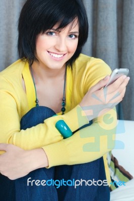 Girl Using Mobile Phone At Home Stock Photo