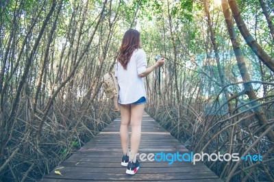 Girl Walking Alone And Hand Holding Camera On A The Wooden Bridg… Stock Photo