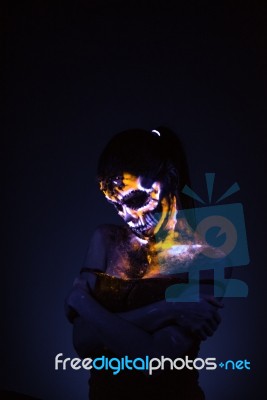 Girl's Face Painted Uv Skull Stock Photo