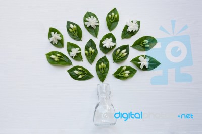 Glass Bottle With Jasmine Flower And Leaves Stock Photo