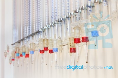 Glass Burettes Hanging At Laboratory Wall Stock Photo