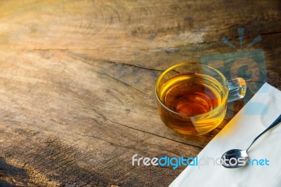 Glass Cup Of Tea And Spoons On Old Wooden Table Stock Photo